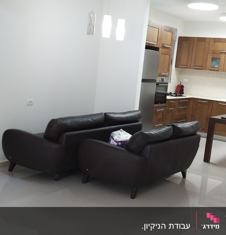 מטבח עם רצפה נקייה ושקית ניירות על הספה